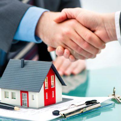 Estate agent shaking hands with customer after contract signature